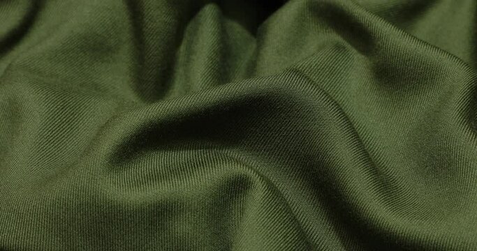 Green fabric background. Green cloth waves background texture. Green fabric cloth textile material.