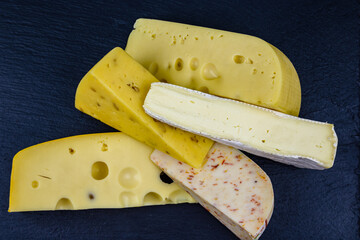 Various types of cheese on a slate board. Top view