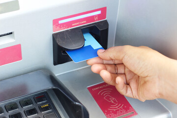 hand is putting ATM card into a machine