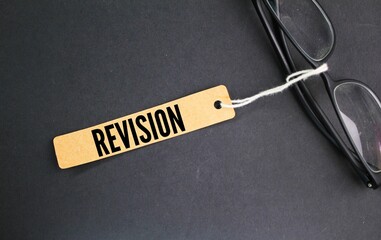 glasses and a paper tag with the word Revision