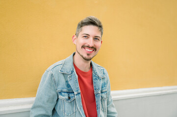 Young hispanic man smiling happy at the city.