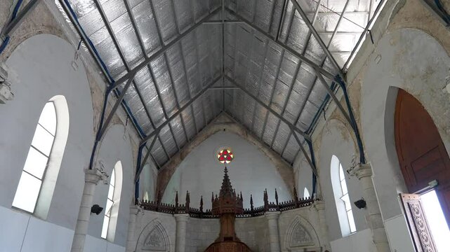Humble interior of a small city church. Metal insolation on ceiling.