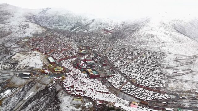 Drone view of the Buddhist Academy located in Larung Gar, Sertar County, Sichuan, which is on the border between China and Tibet. Buddhist religious center in snow.