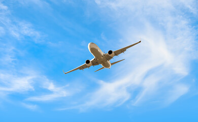 White passenger airplane flying in the sky amazing clouds in the background - Travel by air transport