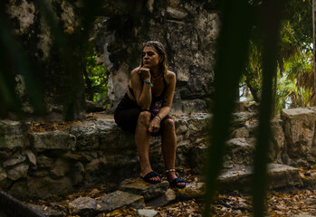 Girl on a dress posing on a Mayan Archeological site in the Jungle of Yucatan