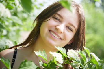 Portrait of a happy girl in the park in summer. Holidays, rest, youth