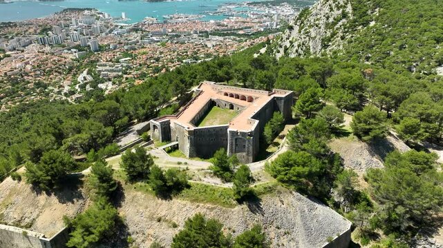 Historic Fort Faron On Mountain Overlooking City Of Toulon On French Riviera In France. aerial pullback, tilt-up