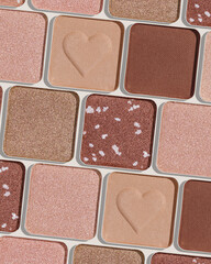 Minimal pattern of eye shadow beige tones swatches, monochrome photo background, eyeshadow with heart imprint, shiny natural shades powder makeup, square shape metal pack, beauty cosmetic texture