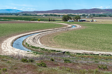 An irrigation ditch makes an S-curve through farm fields in eastern Oregon, USA
