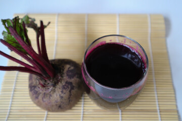 Freshly made beet juice. Healthy Beetroot Juice, cold pressed juice, served in glass with fresh beetroot.