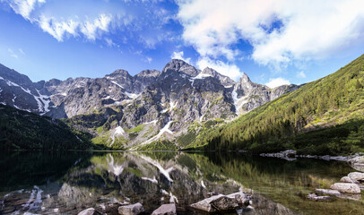 Landscape with lake and mountains. Tatra mountain massif. Lake "Sea Eye" in the Tatra Mountains, Poland. Morskie Oko. Mountain lake. Reflection. Panorama of mountains © Liubov Kartashova
