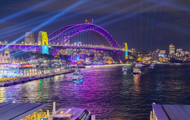 Colourful Light show at night on Sydney Harbour NSW Australia. The bridge illuminated with lasers and neon coloured lights 