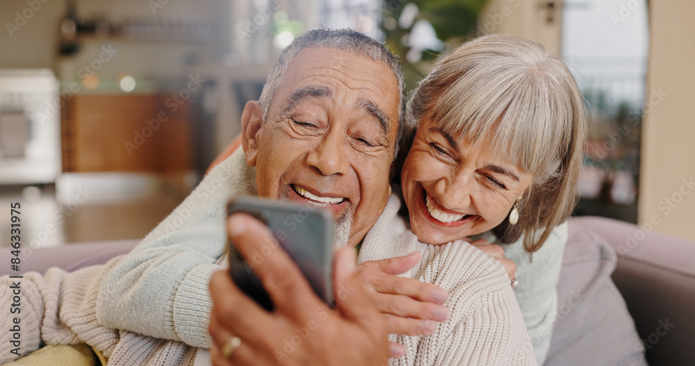 Wall mural Elderly couple, selfie and smile in lounge, hug and together in house, online and photography for memory. Home, profile picture and old man with woman, happiness and app in mobile and love in post