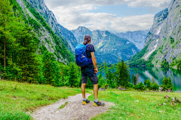 hiker in the mountains. Landscape Scenery. Man is Hiking in the National park Berchtesgadener Land in Summer, Germany. Lake Obersee. Lake Koenigssee, in Berchtesgadener Land, Bavaria, Germany