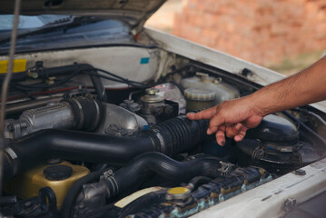 Fototapeta premium Mechanic fixing and inspect broken car. Technician man hand repair and maintenance auto engine at garage shop.