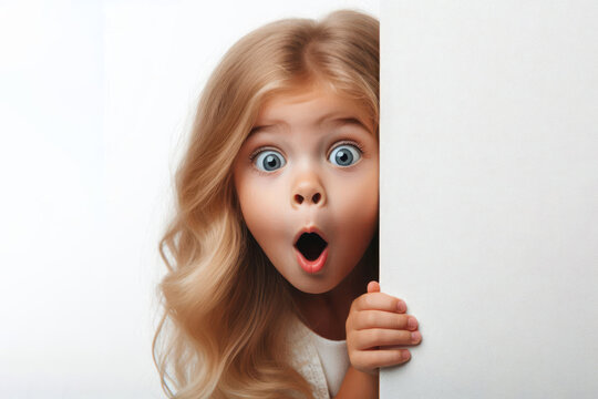 Funny surprised child peeks out from around the corner Isolated on white background