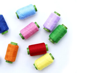 Colourful thread spools on white background
