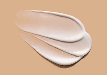 cosmetic smears of creamy texture on a beige background