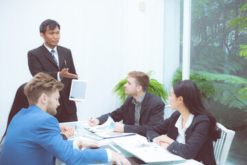 Corporate business team presentation with businessman using tablet in meeting room at modern office, manager or entrepreneur presentation about finance for planning marketing and brainstorming.