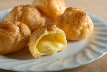 Cream puffs placed on a plate at the table.