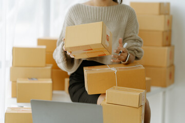 Fototapeta premium businesswoman start small business and successful SME entrepreneurs asian woman hoding boxs works from home delivering parcels online. SME delivery