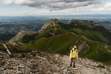Fototapeta premium A girl of European appearance is a traveler on the top of the Polish Tatra Mountains on a summer day.