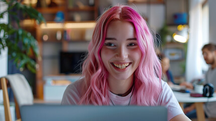 Smiling Young Woman with Pink Hair Working on a Laptop in a Cozy Environment. A young woman with vibrant pink hair smiles as she works on her laptop in a cozy, well-decorated room.