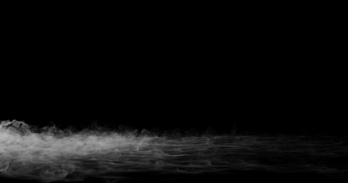 Machine &agrave; fum&eacute;e au sol blanche sur fond noir 4K 60fps