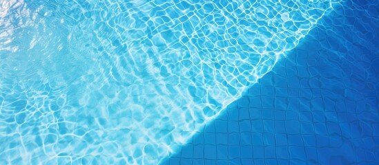 Aerial view of sunlight reflecting on the water surface of a blue tiled swimming pool creating a patterned background with ample copy space image