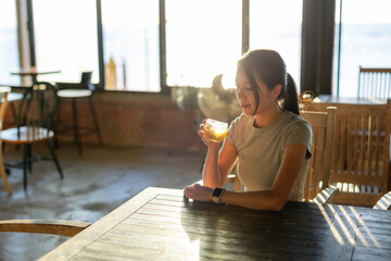 Woman enjoy glass of iced tea at coffee shop