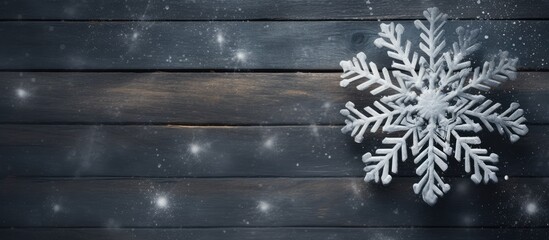 Fototapeta premium A wooden snowflake placed on a snowy chalk background creating a serene copy space image