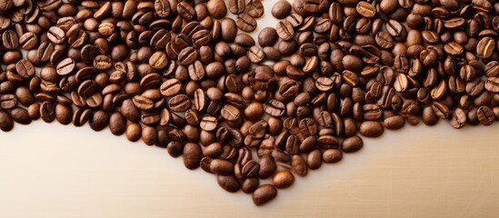 Fototapeta premium A top view of a heart shaped coffee bean on a blank space image. copy space available