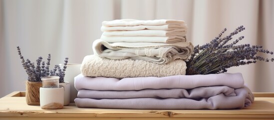 A close up copy space image of neatly folded textile items such as towels napkins linen and cotton terry arranged with dried lavender flowers in a wooden box evoking a sense of order and comfort on a