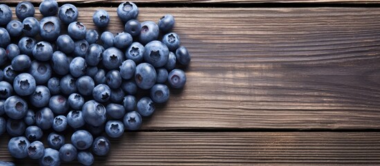 A heart shaped arrangement of blueberries on a wooden surface creating a visually appealing copy space image