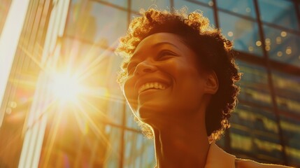 A woman with a big smile on her face is looking up at the sun