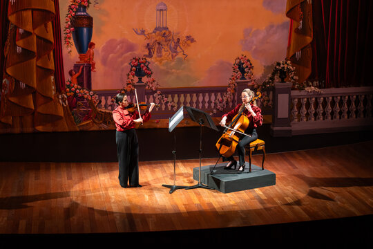 Female cello violin duo. Scene during the concert in the theater.