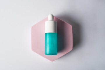 Blue cosmetic bottle, Skin care or sunscreen cosmetic with stylish props on white background.