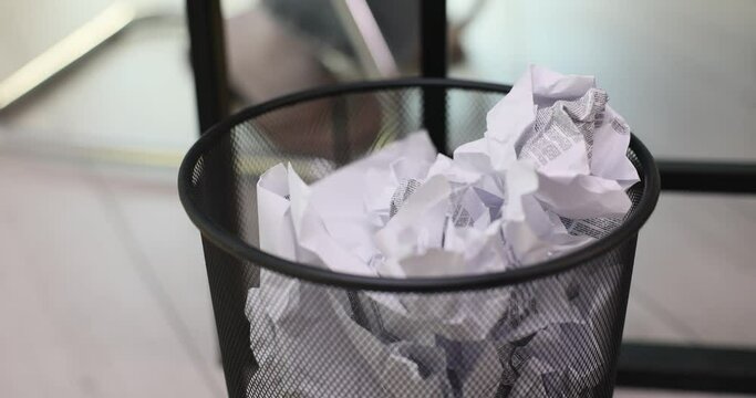 Office worker throws unnecessary document into trash can