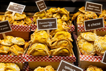 An empanada is a type of pastry baked or fried in Hispanic cultures. Mix set empanadas on outdoors bazar. Closeup of baked snack empanada at market, popular Spanish street food