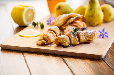 Sweet pastries, puff pastries with pears, on a wooden table