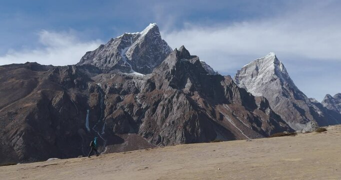 Drone captures a male trekker on the Everest Base Camp trek, Nepal, moving from Dingboche to Lobuche. Majestic mountain scenery in high-resolution. Adventure and nature.