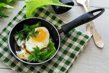fried egg in a frying pan with herbs