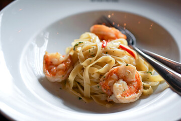 Tagliatelle spaghetti with shrimp, made simple way with garlic, chili, olive oil, parsley and parmesan cheese. Pasta plate in Argentina steakhouse restaurant.