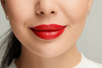 Fototapeta premium Woman with red lipstick on light background, closeup