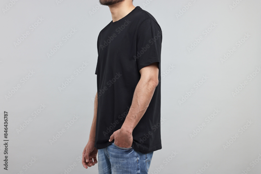 Poster Man in black t-shirt on grey background, closeup