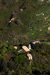Aerial view of a small white church in a mountainous terrain
