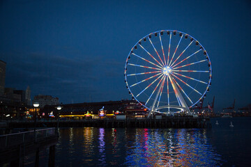 the ferris wheel is brightly lit up on a dark night