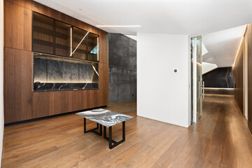 an empty room with wood paneling and a marble coffee table