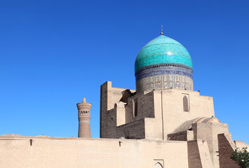 Dome with azure tile of Poi Kalyan Mosque and Kalyan minaret, religious complex of Chor Bakr, Bukhara, Uzbekistan. On blue sky background