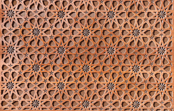 Detail of wooden door with traditional islamic ornament. Wood window shutter with antique iranian geometric pattern. Oriental ornament with artistic carving for wood
